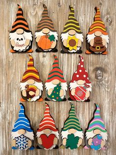 several wooden gnomes with different hats and colors are arranged on a wood table top