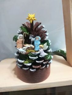 a small christmas tree with nativity figurines on top