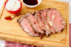 the meat is sliced and ready to be served on the cutting board with sauces