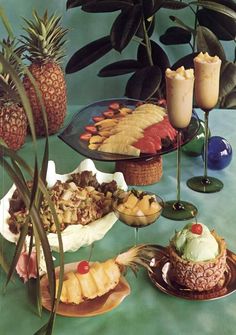 pineapples, bananas, and other tropical foods are arranged on serving platters