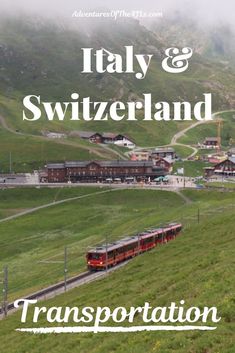 a train traveling down tracks next to a lush green hillside