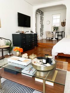 a living room filled with furniture and a flat screen tv on top of a wooden table