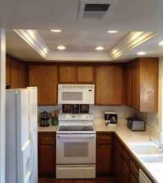 a kitchen with wooden cabinets and white appliances