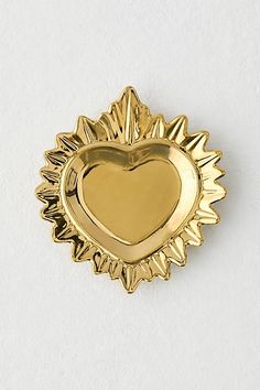 a gold heart shaped dish on a white surface