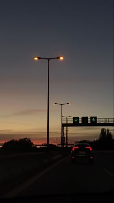 the car is driving down the road at dusk