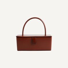 a brown handbag on a white background with the handle extended to it's side