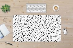 a computer mouse pad with black and white polka dots on it next to a keyboard