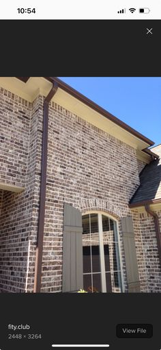 an image of a brick house with shutters on the front and windows in the back