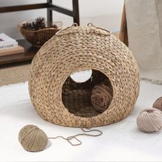 two balls of yarn are sitting on the floor next to a basket