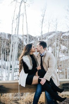 a man and woman sitting on a bench kissing