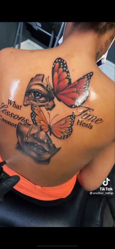 a woman's back with butterflies and words on it