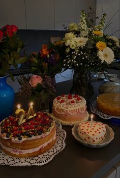 a table topped with cakes and flowers on top of it