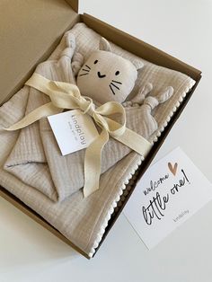 an open box with a stuffed animal in it and a card on the inside that says welcome kitty to me