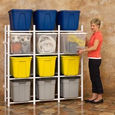 a woman standing in front of a shelf filled with plastic bins