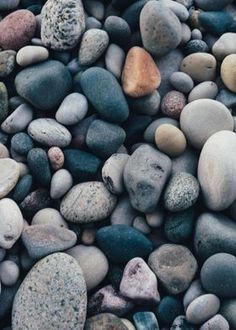 many rocks are arranged together on top of each other in different colors and shapes,