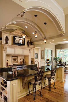 a large kitchen with an island and two bar stools next to the counter top