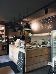 the inside of a coffee shop with menus on the wall and lights hanging from the ceiling