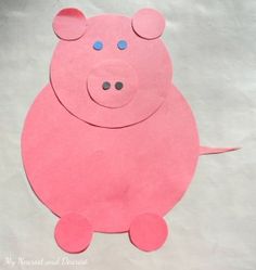 a paper cut out of a pink pig sitting on top of a white sheet of paper