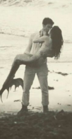 a man carrying a woman on his back at the beach