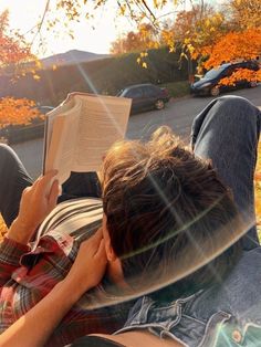 a person laying on the ground reading a book