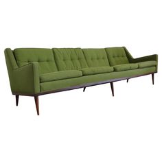 a green couch sitting on top of a white floor