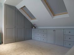 an attic bedroom storage room with drawers and cupboards