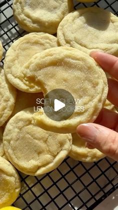 a person is holding up some cookies on a cooling rack with lemons in the background