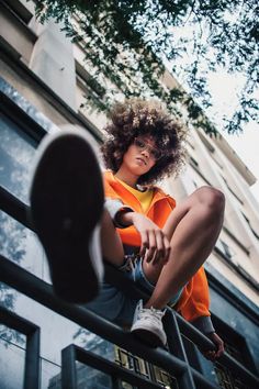 a woman sitting on top of a metal rail