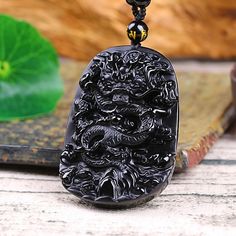 The Oriental dragon black stone necklace features the stunning black Obsidian stone that has been carved to form a perfect dragon shape. Wearing the dragon amulet will help bring wisdom and prosperity to your life, so you can enjoy a stunning necklace that offers you the best of both worlds. As Obsidian is a natural protector, it has been used for healing purposes for years. It holds natural powers that will remove the negative energy from your body, and release disharmony from your body. Moreov Black Jewelry With Dragon Design For Gift, Black Dragon Design Jewelry Gift, Black Obsidian Amulet Necklaces, Black Obsidian Necklaces For Meditation, Black Obsidian Necklace For Meditation, Black Obsidian Amulet Necklace, Spiritual Black Jewelry With Dragon Design, Black Spiritual Jewelry With Dragon Design, Black Carved Spiritual Necklace