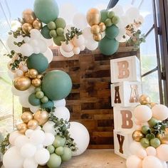 a baby shower with balloons and greenery