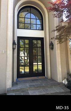 the front entrance to a home with black doors