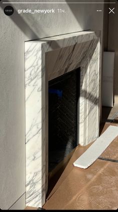 a white marble fireplace with the door open