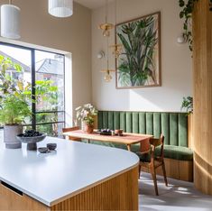 a kitchen with an island in front of a window and potted plants on the counter