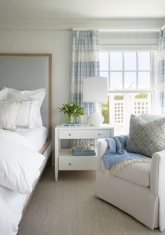 a bedroom with white furniture and blue curtains