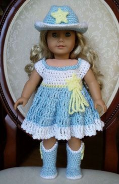 a doll is wearing a blue dress and hat with yellow stars on the top, while standing in front of a chair