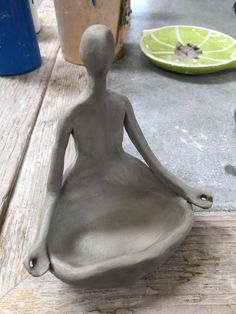 a clay figure sitting on top of a wooden table