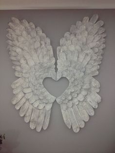 a heart shaped angel wings hanging on the wall