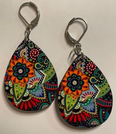 A navy blue background is covered with beautiful flowers and colors to create this pair of earrings you will love to wear! Colorful Earrings As A Gift, Vibrant Colorful Earrings For Gifts, Colorful Hand-painted Drop Earrings, Colorful Hand Painted Drop Earrings, Multicolor Hand Painted Drop Earrings, Colorful Vibrant Earrings With Ear Wire, Multicolor Flower Drop Earrings For Gift, Blue Bohemian Teardrop Flower Earrings, Fun Blue Hand Painted Earrings