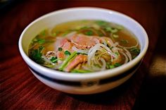 a white bowl filled with soup on top of a wooden table