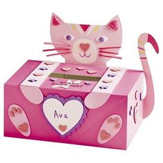 a pink cardboard box with a cat on top and hearts in the bottom, sitting next to it