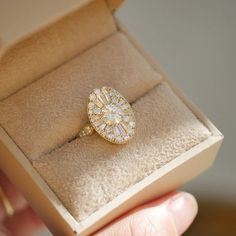 a person is holding an engagement ring in a box that has been opened to show it's inside