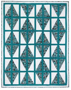 a blue and white quilt with an intricate design on the front, along with two rows of diamonds