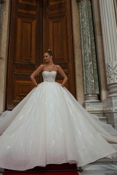 a woman standing in front of a door wearing a wedding dress