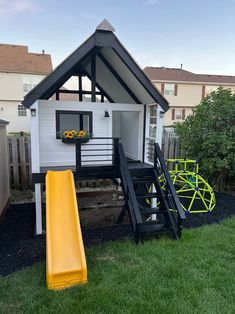 a small house with a slide in the yard