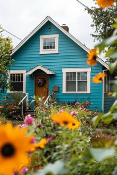 a blue house with flowers in front of it