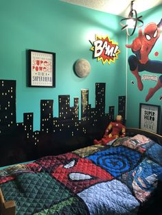 a child's bedroom with spiderman and batman pictures on the wall above the bed