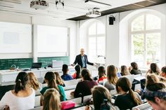 a man standing in front of a class room full of students