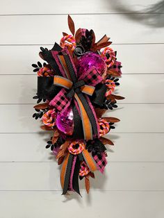 a pink, black and orange wreath hanging on the wall