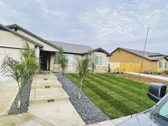 the front yard of a home with grass and landscaping