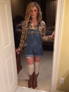 a woman standing in front of a door wearing denim overalls and knee high socks